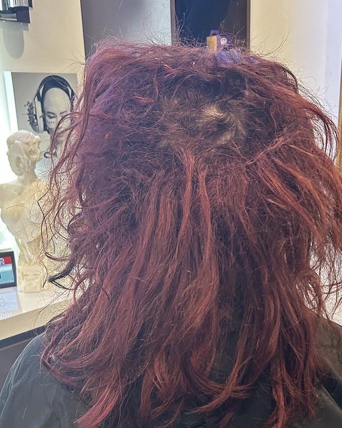 Before keratin-tip hair extensions: tangled, matted red hair from extensions done elsewhere