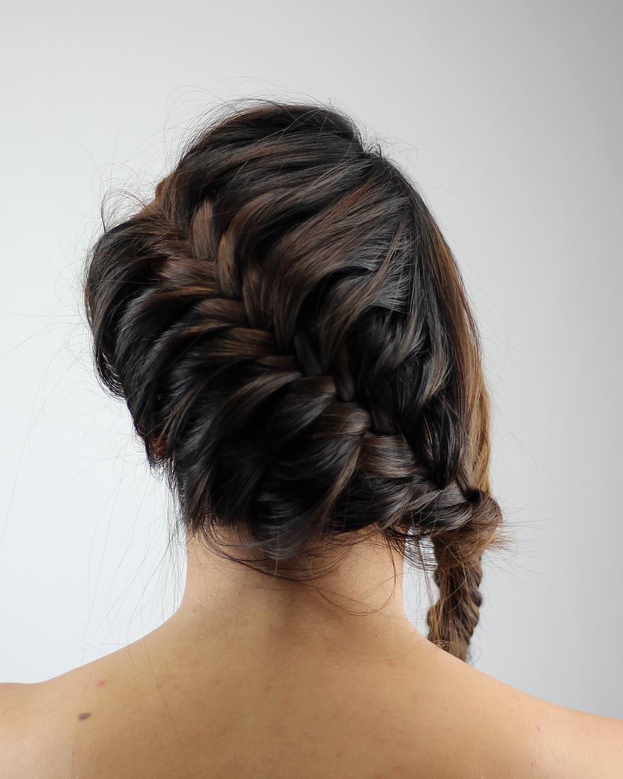 Dark brunette French braid wrapped into a low side knot