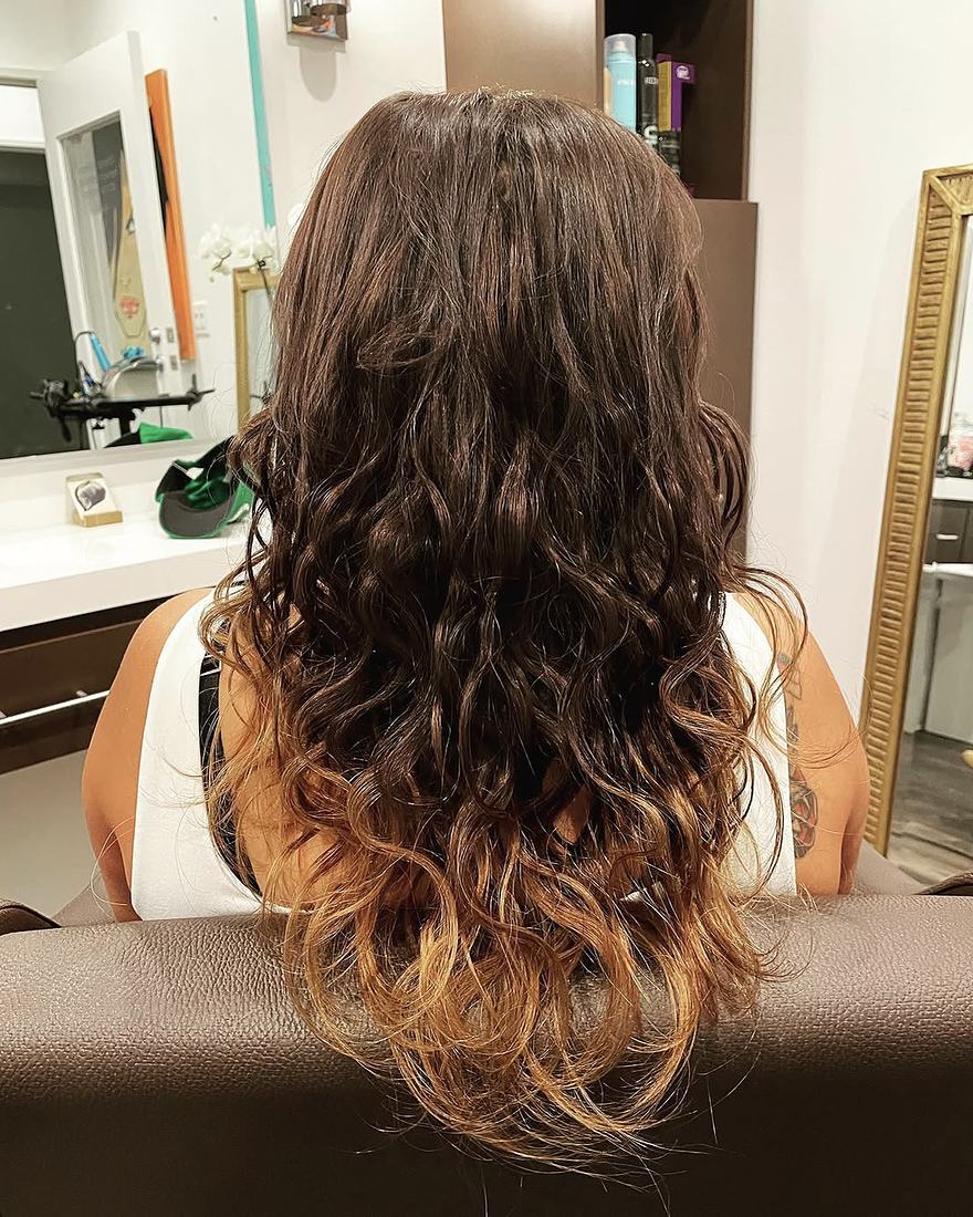 After keratin-tip hair extensions: restored fullness with long brunette waves and golden ends