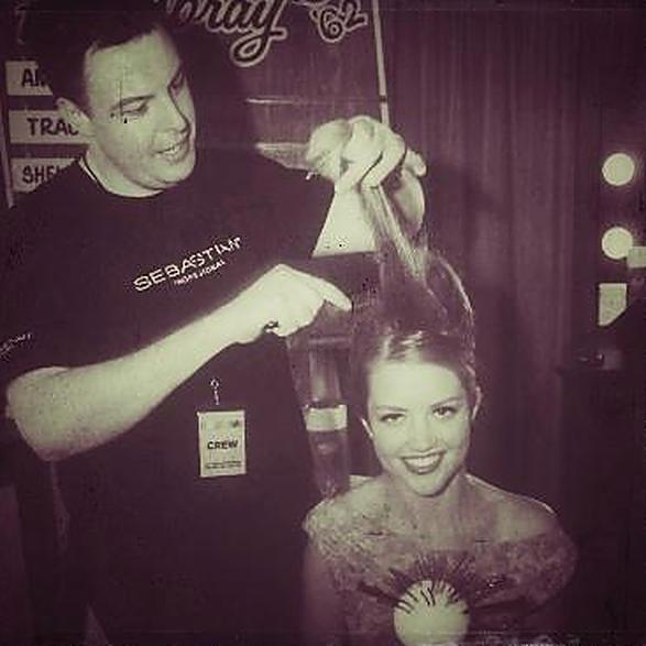 Backstage, Christopher teasing a smiling model's crown while wearing a crew badge