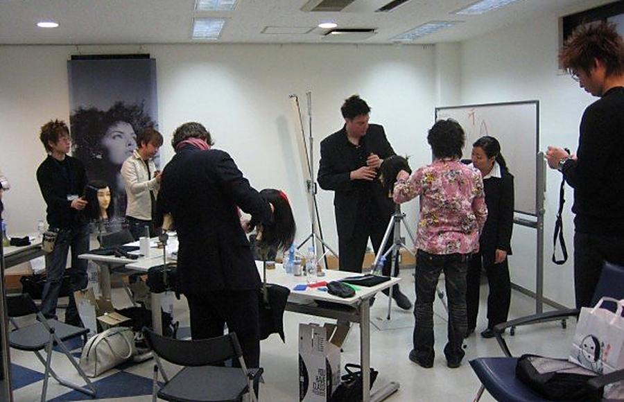 Hands-on workshop with stylists cutting on mannequin heads while Christopher demonstrates