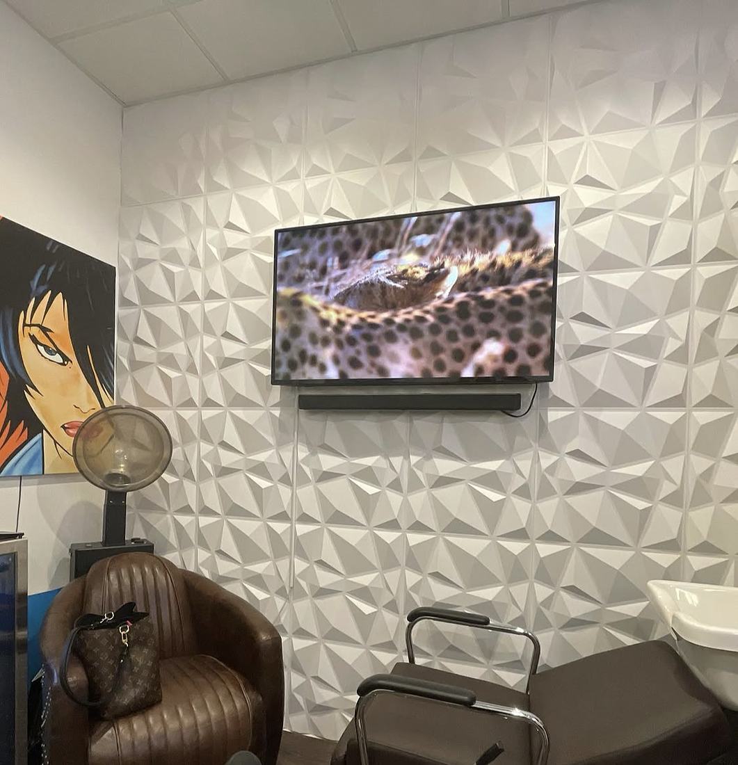 Christopher's private suite with a styling chair, shampoo bowl, and textured white wall